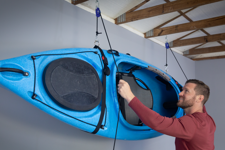 Kayak hoisted effortlessly using Tie Boss pulley system in a garage.